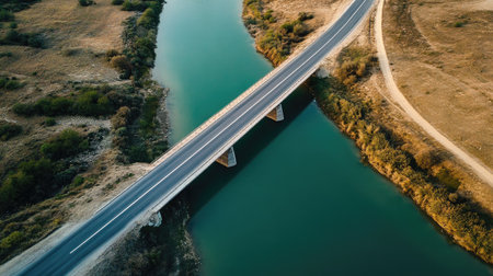 Long empty road crossing a bridge over a river, aerial view with ample copy space available.の素材