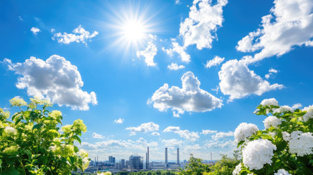 A stunning view capturing bright sunshine illuminating a vibrant cityscape, framed by blooming flowers, under a clear blue sky filled with fluffy clouds.の素材