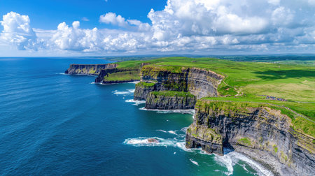 This breathtaking image showcases dramatic cliffs towering over vibrant turquoise waters, with a stunning blue sky filled with soft clouds, creating a serene atmosphere.の素材