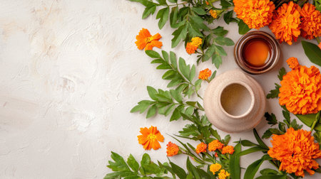 A serene composition featuring marigold flowers and an herbal pot surrounded by vibrant orange petals and green leaves on a textured white background.の素材