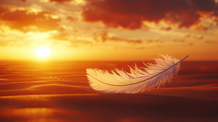 A graceful white feather gently rests on smooth golden sand during a captivating sunset. The warm sunlight and soft clouds create a tranquil atmosphere.の素材