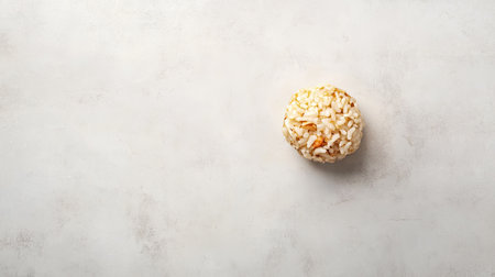 A beautifully styled single round rice ball sits on a neutral background, perfect for showcasing culinary art in food photography and recipes.の素材