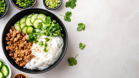 A vibrant Asian cuisine bowl featuring fresh noodles, succulent meat, and a variety of colorful vegetables and herbs, perfect for a nutritious meal.の素材