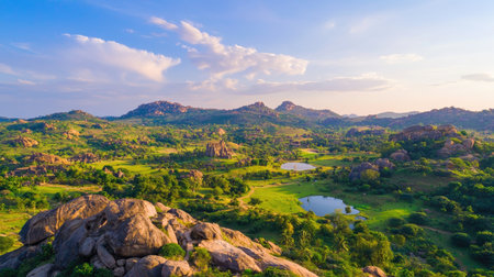 A stunning view of a natural landscape featuring rolling hills, rocky formations, and serene water bodies under a vibrant sunset sky. Perfect for nature enthusiasts.の素材