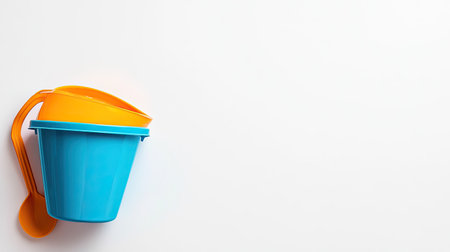 A vibrant beach pail and spade on a plain white backdrop, with plenty of space for textの素材