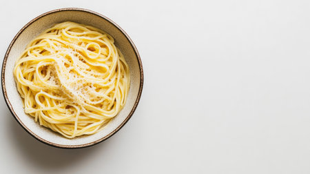 Top view of a bowl of linguine with parmesan cheese on a white background, leaving space for copyの素材