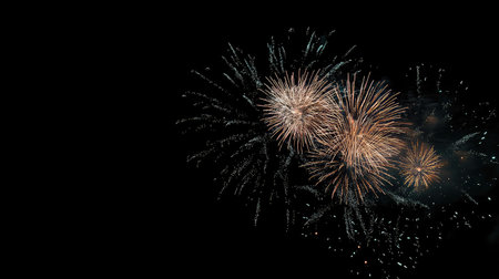 Fireworks bursting in celebration over the night sky, with clear copy space below.の素材