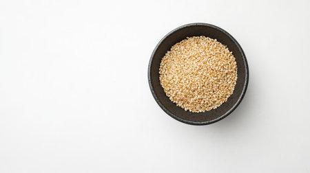 Top view of a rice bowl with sesame seeds, placed on a white table with ample copy spaceの素材