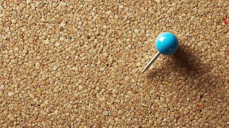 Top view of a pin stuck in a corkboard, leaving ample space for copy or textの素材