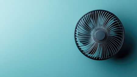 Battery-operated fan with a compact design, cooling a small area. Top view with space for copyの素材