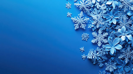 A stunning frosty blue background featuring a graceful arrangement of flowers and snowflakes, perfect for winter-themed designs and seasonal projects.の素材