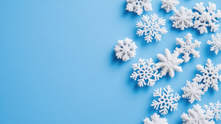Beautiful snowflakes scattered on a light blue background, perfect for winter themes, seasonal decorations, and artistic designs.の素材