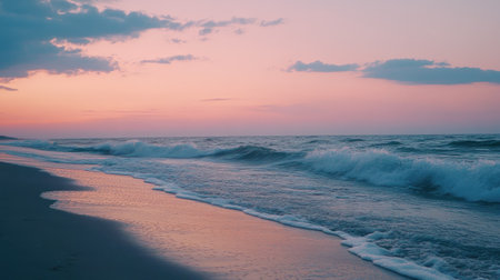 Serene beach scene at dusk with a colorful sunset and gentle waves lapping the shoreの素材