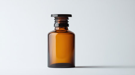 This image features an empty amber glass bottle with a black cap against a light background, ideal for product mockups or packaging designs.の素材