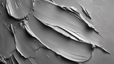 An abstract close-up of a textured gray surface featuring smooth paint swatches arranged in fluid, angular patterns, perfect for art and design projects.の素材