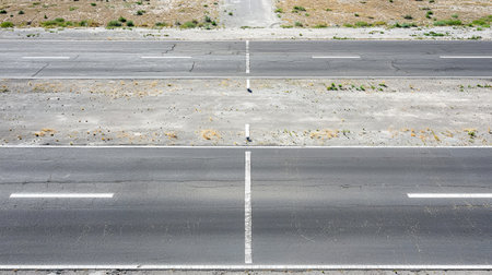 Aerial perspective of an empty road with dramatic shadows and copy space.の素材