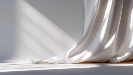 Soft white fabric draped gracefully creates a serene atmosphere, highlighted by gentle shadows and natural light against a minimalist backdrop.の素材