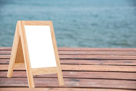 Write a message on a piece of wood in the background blurred sea on a wooden boardの写真素材