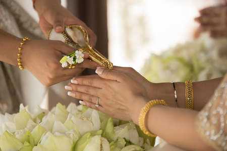 hands pouring blessing water into bride's bands, Thai wedding ceremonyの写真素材