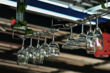 Glass glasses hanging above the bar rackの写真素材