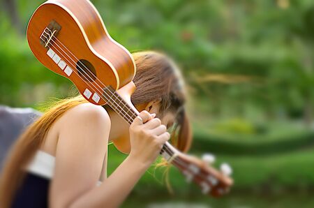 Focus blur women raised ukulele.の写真素材