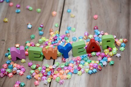 Happy New Year wooden letters on an abstract background.