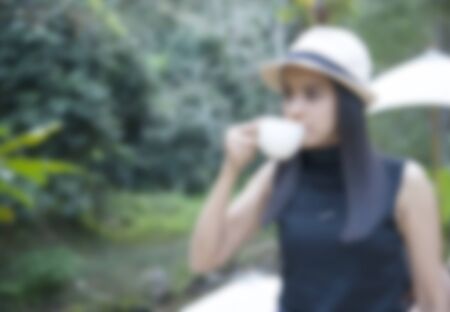 businessman and a cup of coffee in hand, blank text and soft focus blurの写真素材