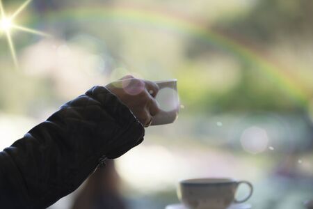 businessman and a cup of coffee in hand, blank text and soft focus blurの写真素材