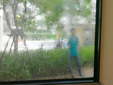 Blur unknown workers are cleaning the glass by tearing the water from the hose
