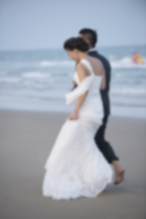 < mixed Blur the married couple walking on the beach happy and romantic love scene.の写真素材