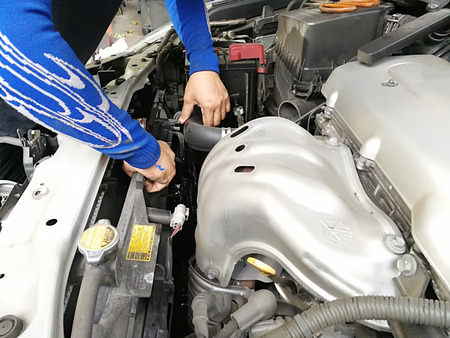 Hands of car mechanic in auto repair service on Metal background