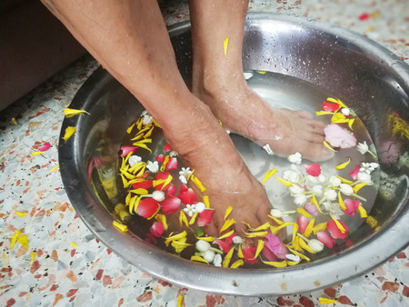 Pour water on the hands of revered elders and ask for blessing in Songkran festival and party background wallpaper concept.の写真素材