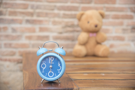 Teddy bear with blue clock on backdropas a background or wallpaper.の写真素材