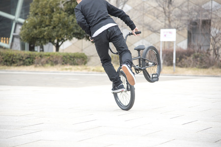 Men do not see the face is playing with bmx bike on Texture background