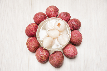 Peeled lychee in a bowl and fresh fruit on the sideの写真素材