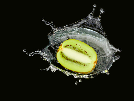 kiwi fruit with water spray on black background or wallpaper.の写真素材