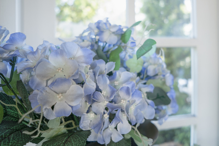 Artificial flowers in a stretcher placed on a window background.の写真素材