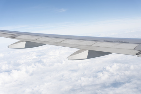 The plane wings are in the atmosphere of beautiful cloudsの写真素材