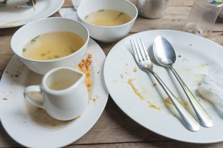 Empty and dirty dish after eating On a wooden floor backgroundの写真素材