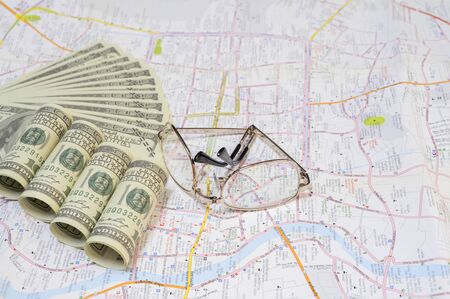 Top view with dollar and glasses in the background of the mapの写真素材