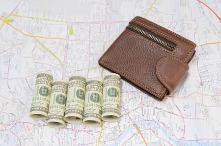 A wallet with a dollar on the travel map backgroundの写真素材