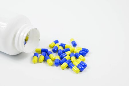 Tablets and bottles to treat symptoms on a white backgroundの写真素材