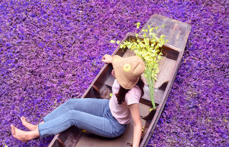 A boat with yellow flowers on an old wooden boat on a natural backgroundの写真素材