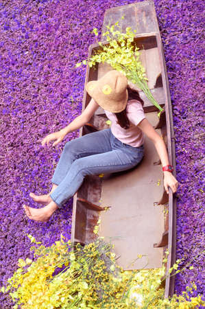 The girl who doesn't see the face on the boat with flowers on a natural background