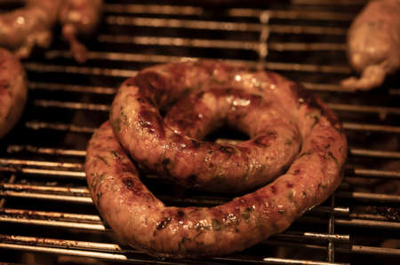 Juicy beef sausage rolls grilled on a grill fireの写真素材