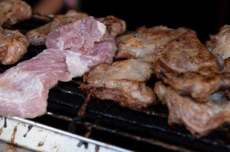 Several pieces of pork are being grilled in a charcoal turtleの写真素材