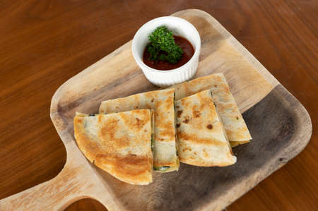 Crispy pizza on wooden plates with sauce cups on the tablewareの写真素材
