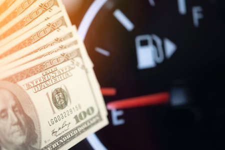 Dollar bank money coming from car fuel mileage dashboard concept closed on financial backgroundの写真素材
