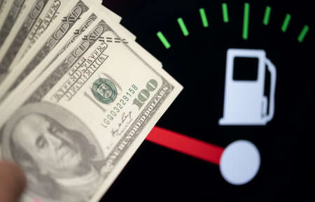 Dollar bank money coming from car fuel mileage dashboard concept closed on financial backgroundの写真素材