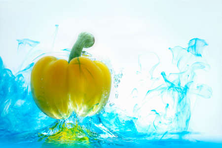 Yellow bell pepper, cut into pieces, splashes into the water. food ingredient concept